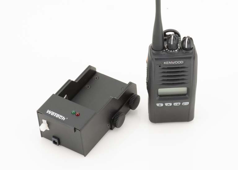 Funkgerät und Ladegerät auf weißem Hintergrund.