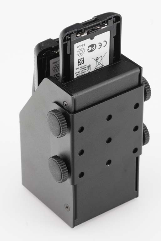 Schwarzes Gerät mit zwei eingelegten Akkus, sichtbar sind Symbole und Schriftzeichen.