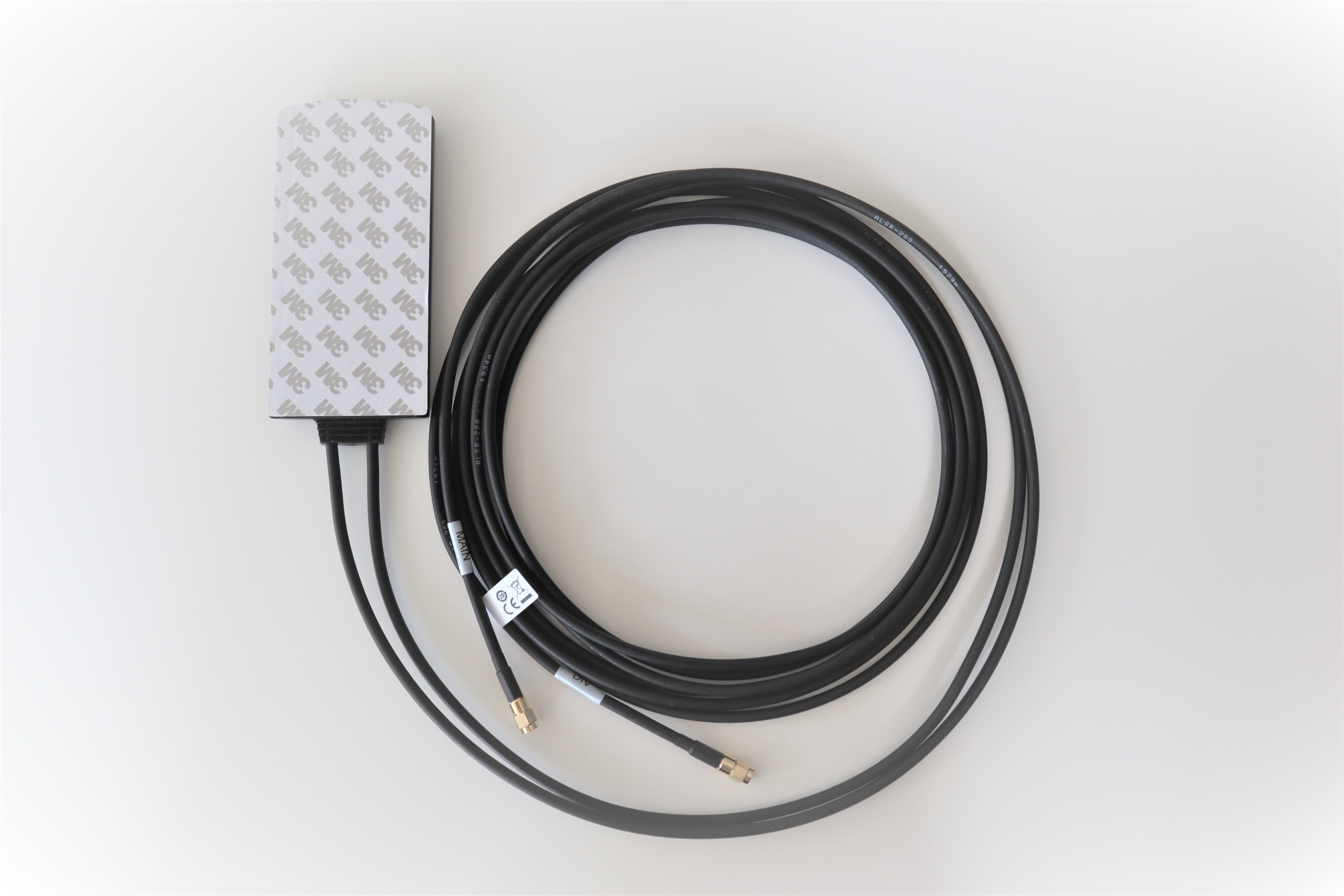 Antenna cable with rectangular case and adhesive label, in black.