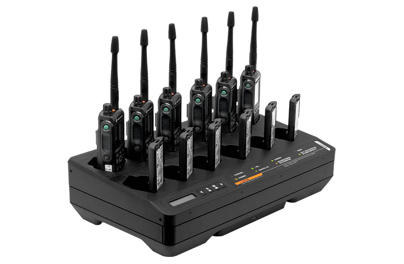 Charger with eight radios in slots, LED indicators lit.