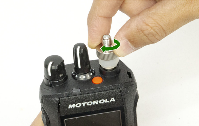 Hand dreht Antenne auf Motorola Funkgerät.