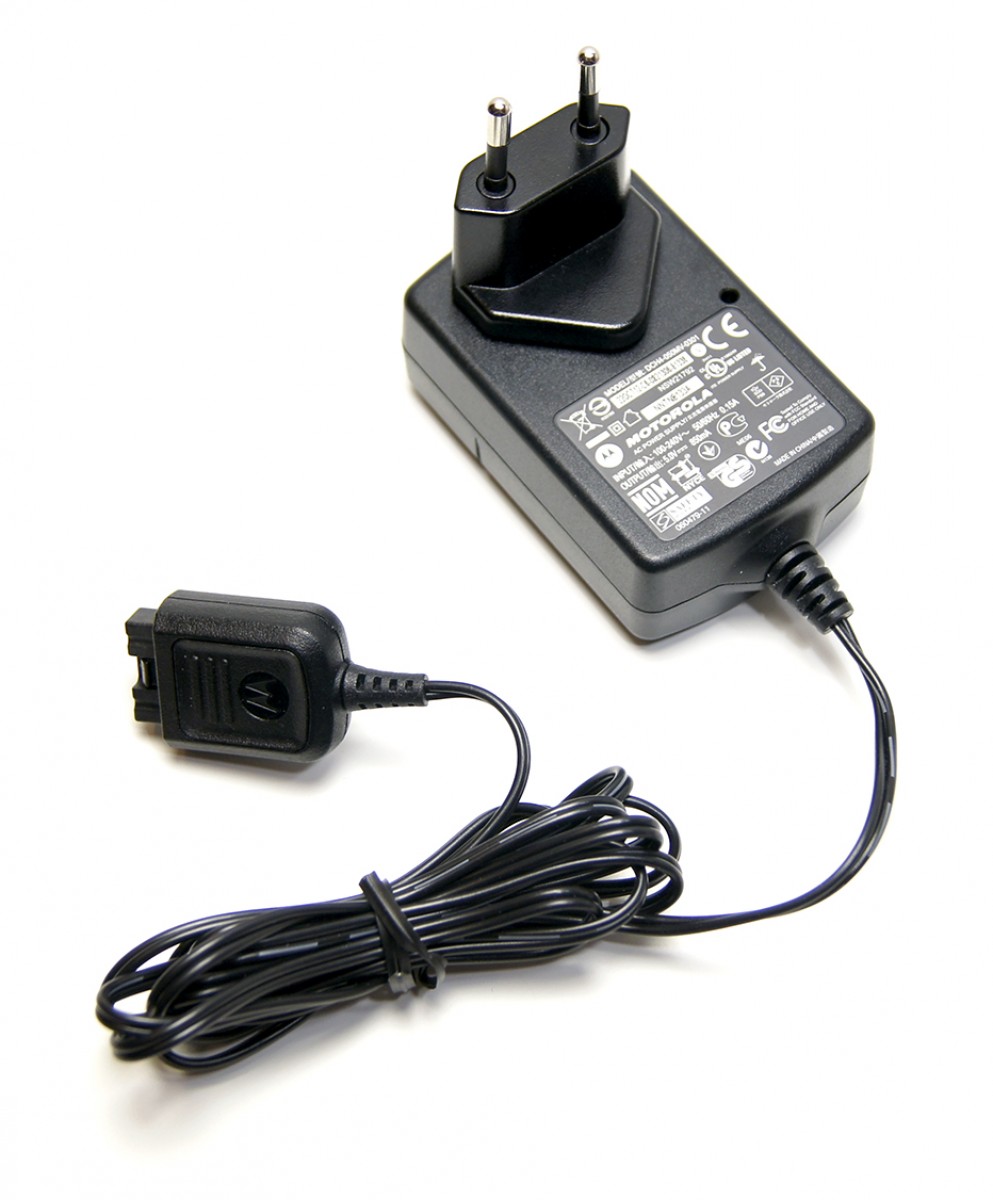 7000-00281900_mot_01kfjeucs3zfb9f.jpg Schwarzes Netzteil mit zwei Stiften und Kabel, Motorola-Logo sichtbar.