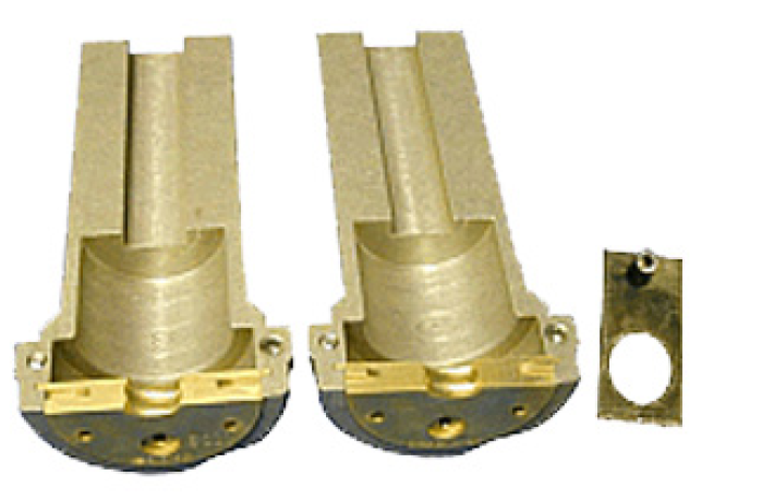 Zwei goldfarbene Metallteile mit Halterung, daneben flaches rechteckiges Metallstück mit Loch.