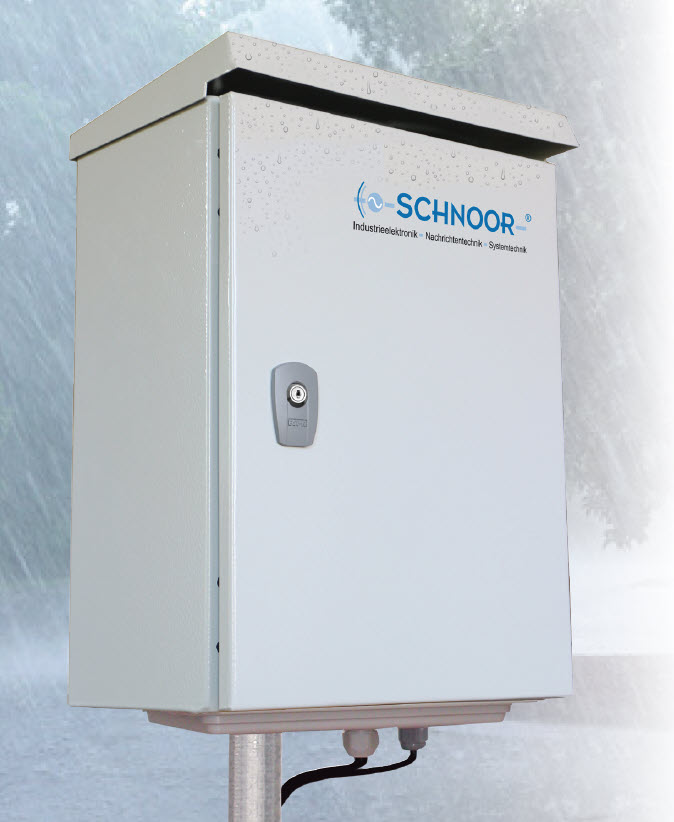 Gray control box with lock, mounted on a pole under rainy sky.