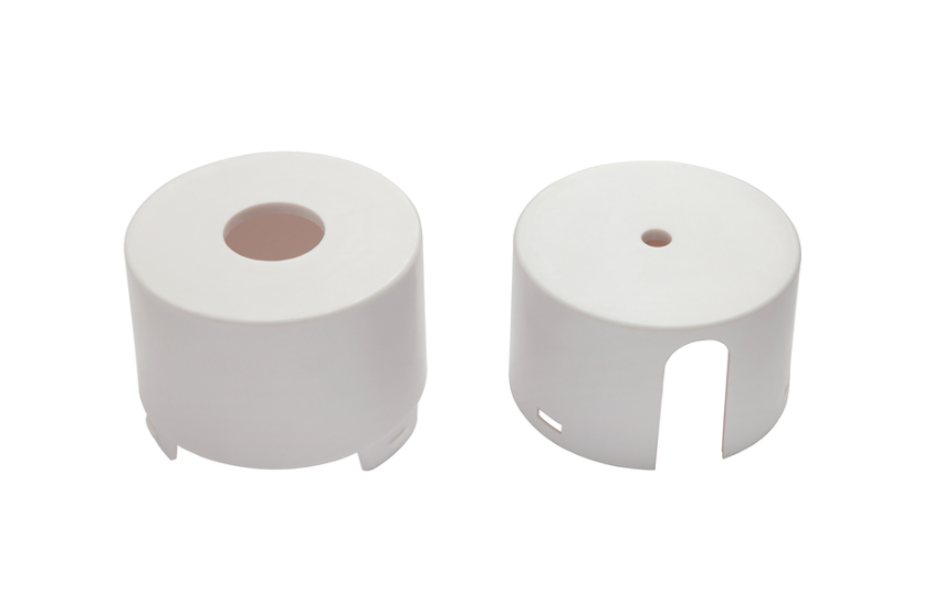 Two white, cylindrical plastic parts with openings.