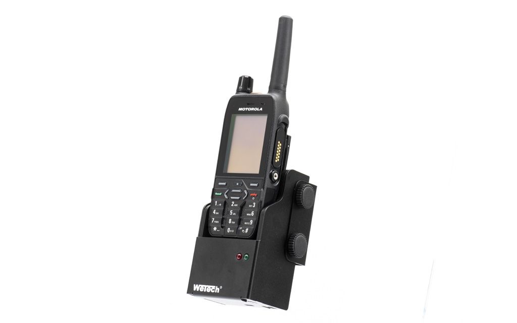 Handheld radio with display and keypad in black holder.