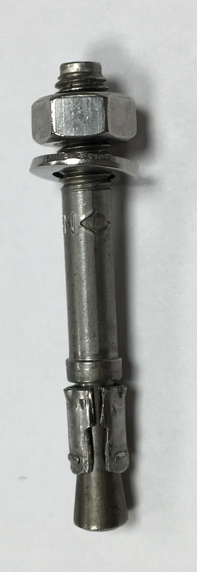 Metallspreizdübel mit Sechskantmutter und Unterlegscheibe auf weißem Hintergrund.