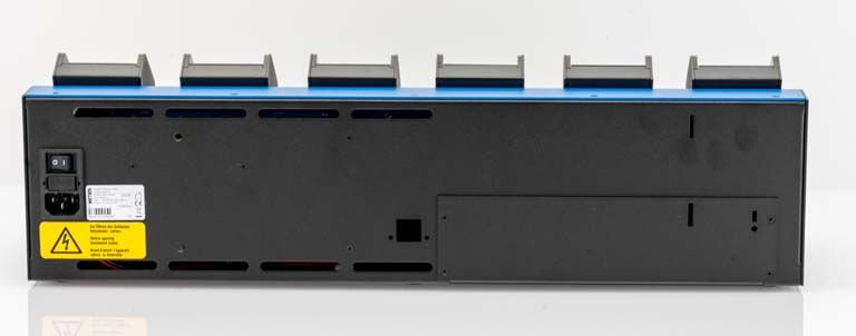 Rückseite eines elektronischen Geräts mit Stromschalter und Warnhinweis auf gelbem Etikett.