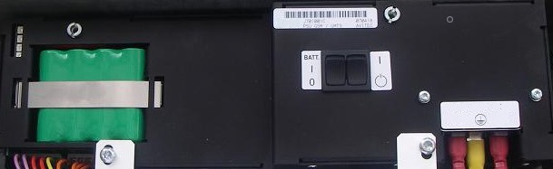 Elektronisches Bedienfeld mit Schaltern und grüner Komponente links.