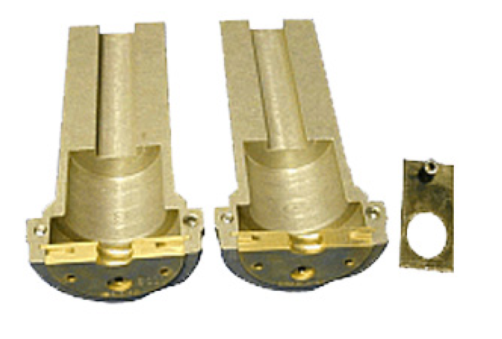 7000-00628100_rfs_01.png Zwei Messing-Gehäuse neben einem rechteckigen Metallstück mit Rundloch.