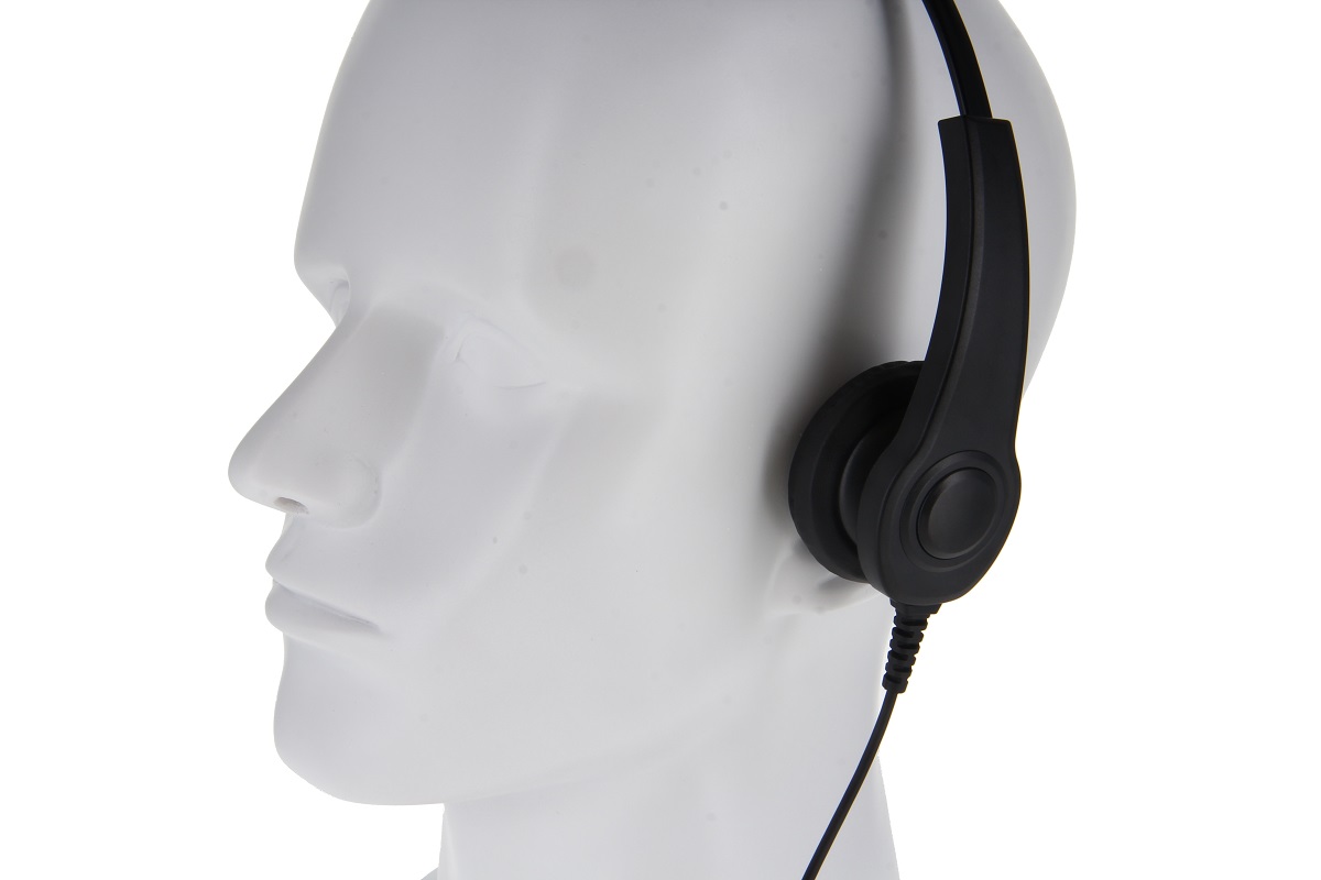 White mannequin head wearing black headphones with cord.