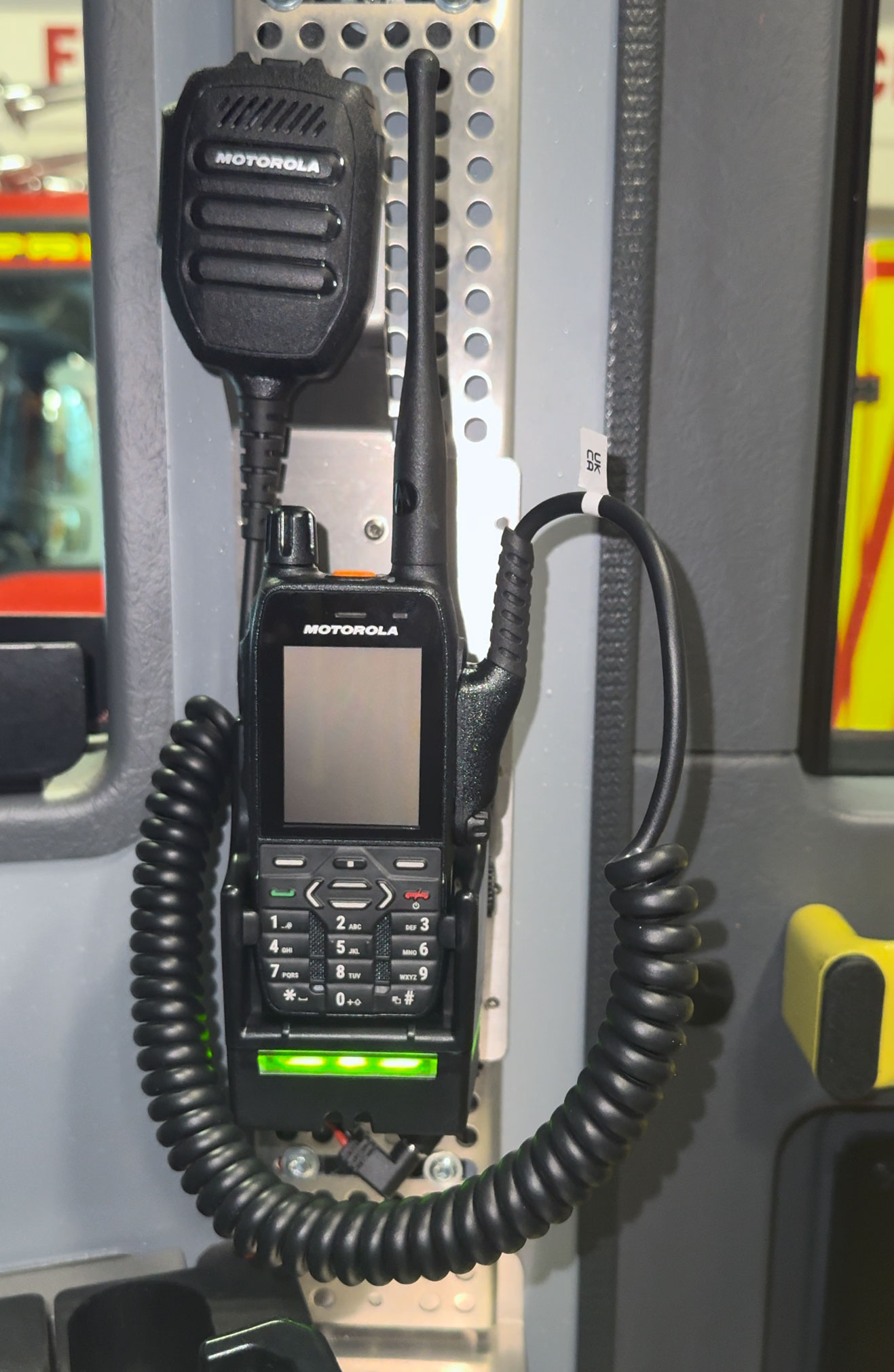 Radio device with microphone holder mounted in a vehicle.