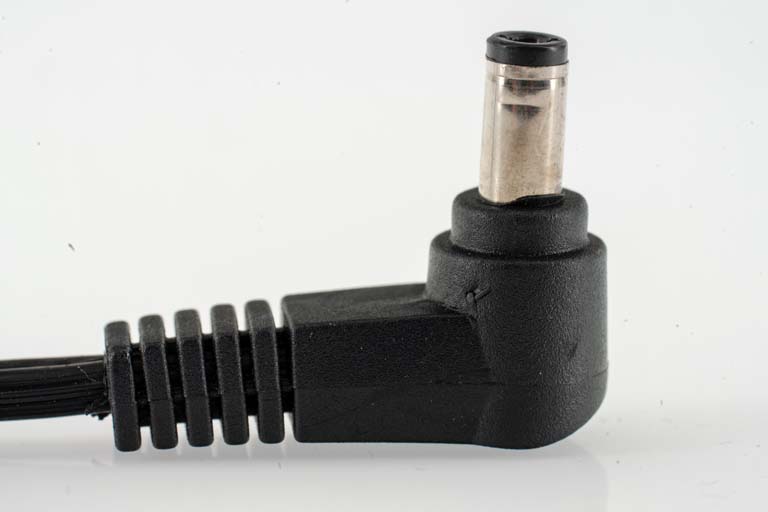 Black power adapter plug with angled tip.