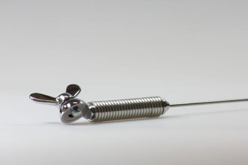 7000-00203800_kat_01.jpg Metalltürstopper mit federbelastetem Design, auf einer stabilen Unterlage.