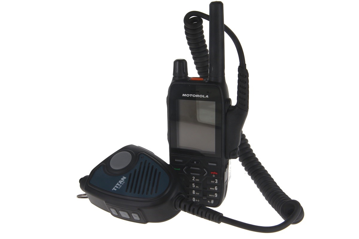 Radio device and handheld microphone connected by coiled cable.