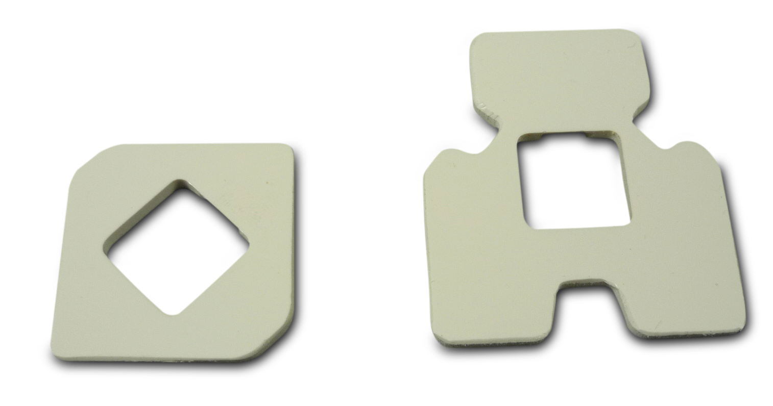 Two white plastic pieces with different shapes and cutouts.