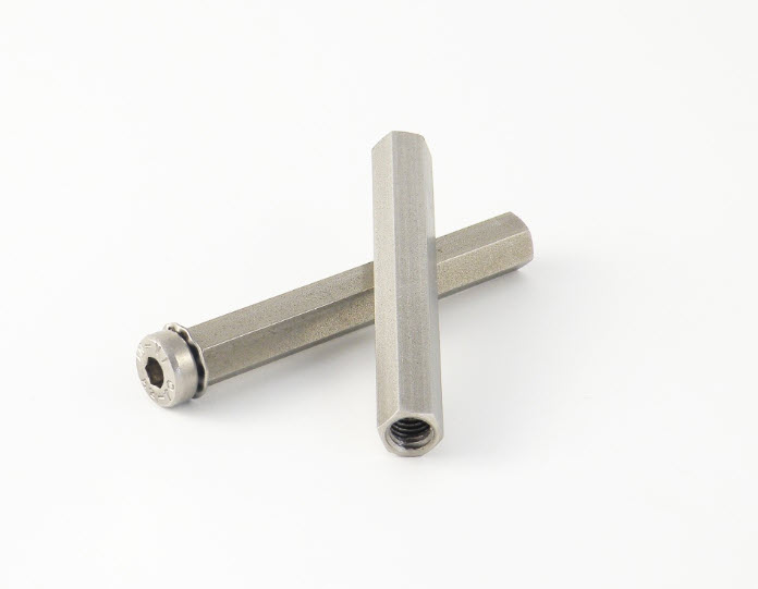 Zwei hexagonale Aluminiumabstandshalter auf weißem Hintergrund.