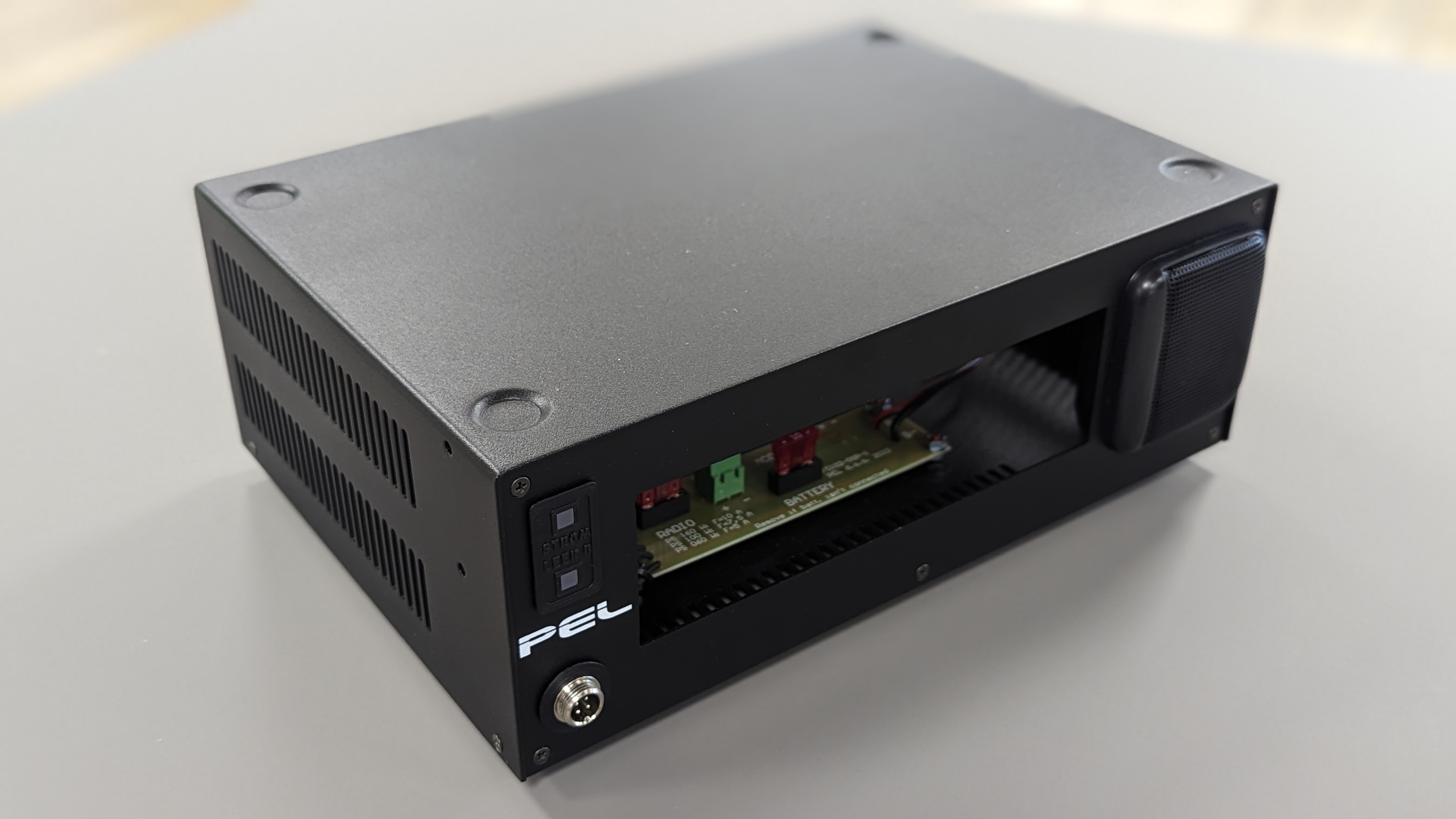 Schwarzes Elektronikgehäuse mit offenen Seiten und sichtbaren Schaltplatinenkomponenten.