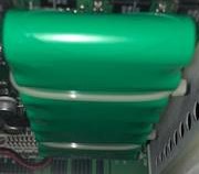 7000-00105400_axw_01.jpg Grüner Kondensator innerhalb eines elektronischen Geräts.