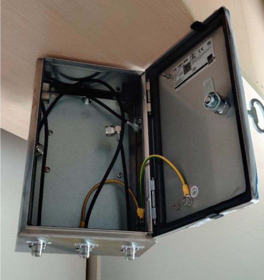 Metal enclosure with open lid, yellow and black cables visible inside.