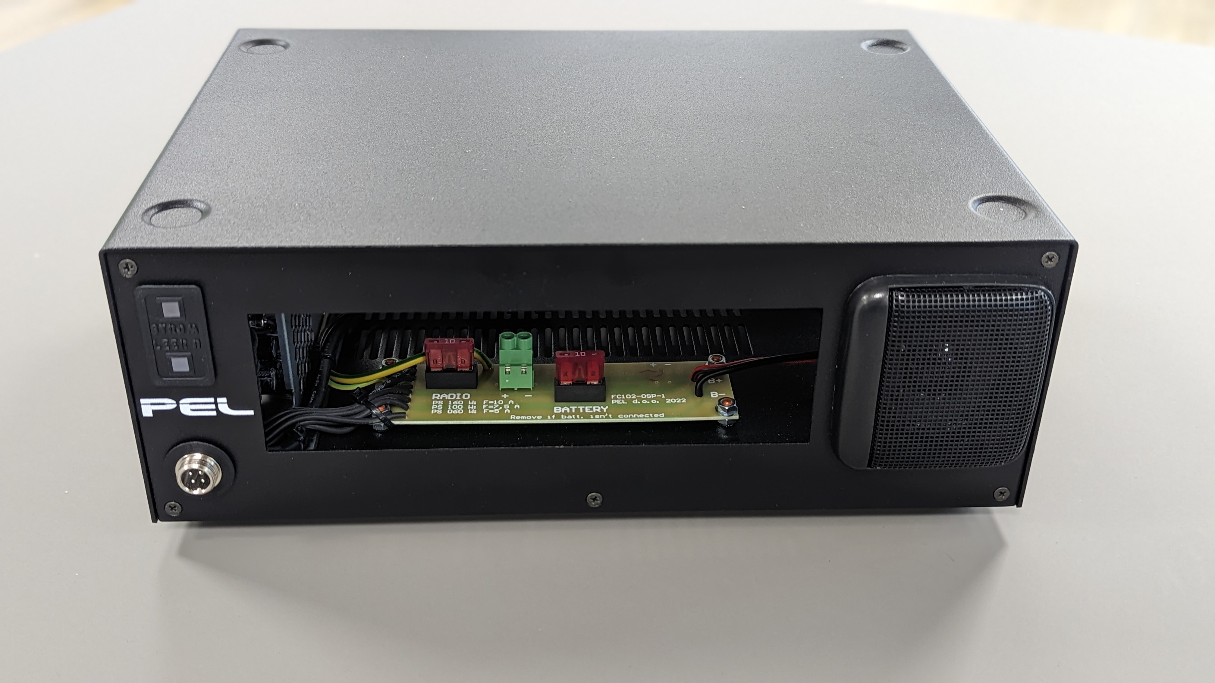 Elektronisches Gerät in schwarzem Gehäuse mit offenem Fach und sichtbaren Kabeln.