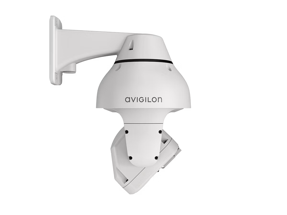 Weiße Überwachungskamera mit Wandhalterung, Avigilon-Logo sichtbar.