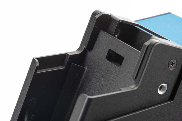 Schwarzes Kunststoffgehäuse, teilweise geöffnet, mit Schraubenlöchern.