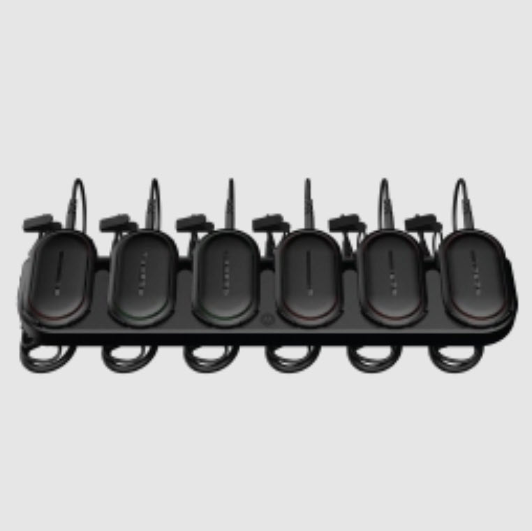 Six black chargers in a docking station with cables.