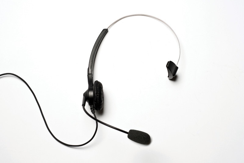 7000-00367100_mot_01.jpg Ein schwarzes Headset mit Mikrofon und einem Ohrhörer auf weißem Hintergrund.