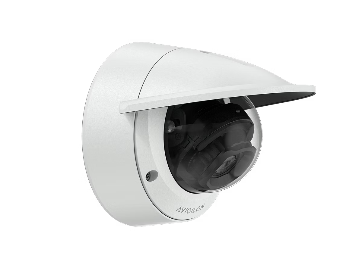 Weiße Überwachungskamera mit Schutzhülle an einer Wand.