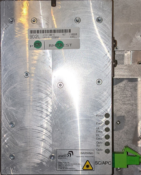 Metallgehäuse mit Etikett, mehreren LEDs und grüner SC/APC-Buchse an der Seite.