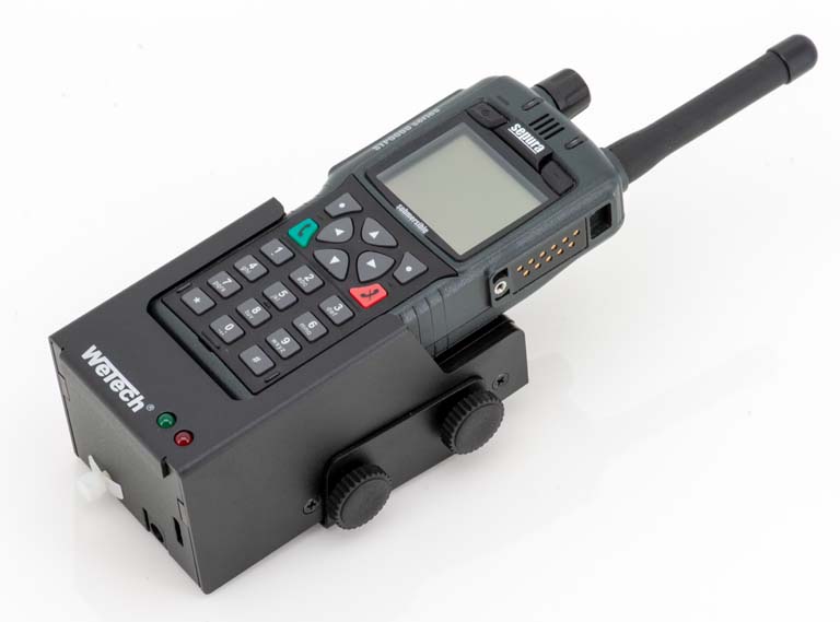 Handfunkgerät mit Ladegerät und Antenne auf weißem Hintergrund.