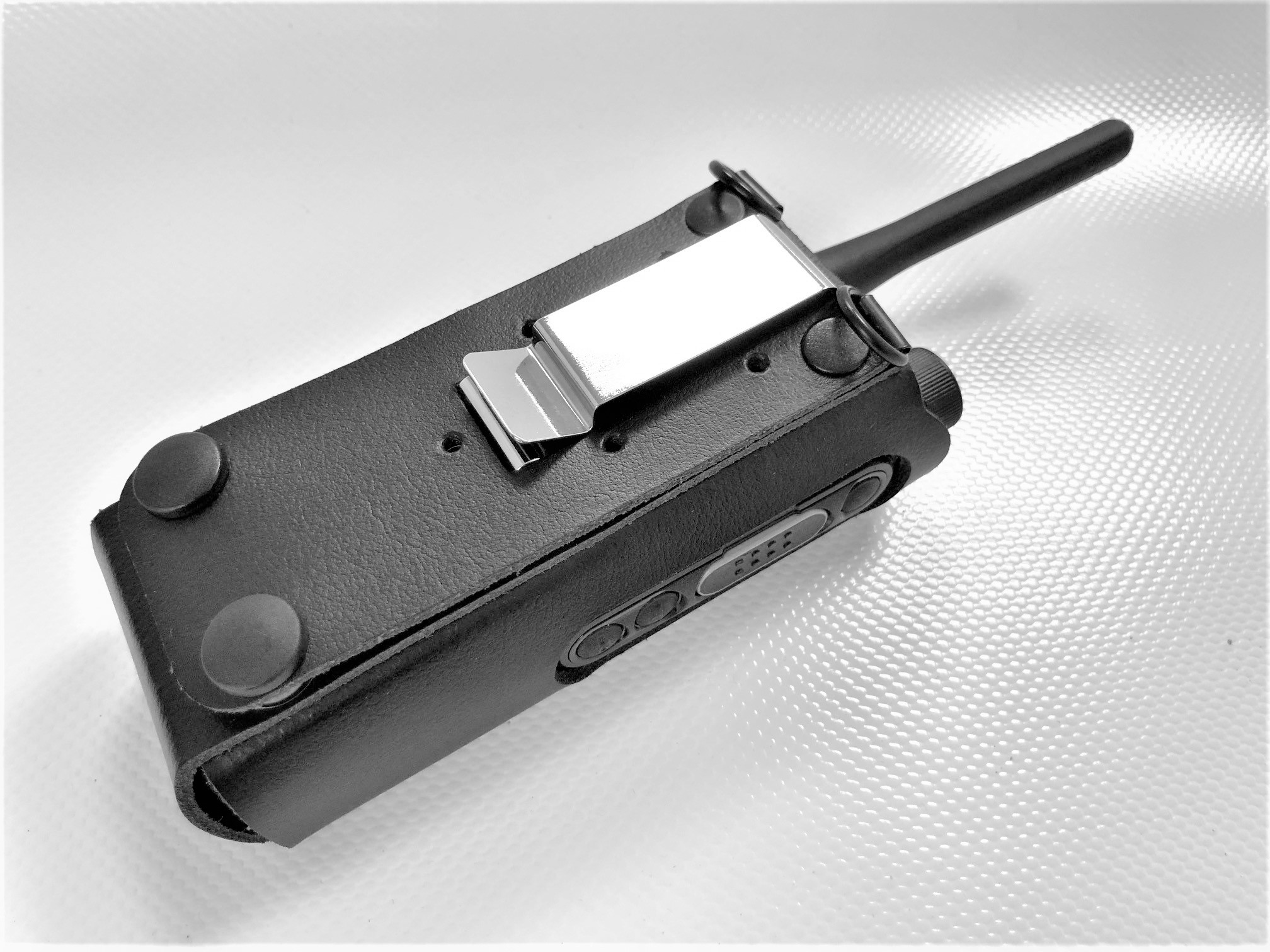 Portable radio in a black leather case with antenna.