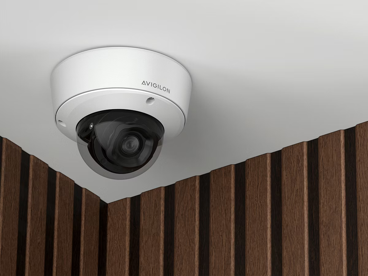 Surveillance camera on a ceiling, walls with wood panels.