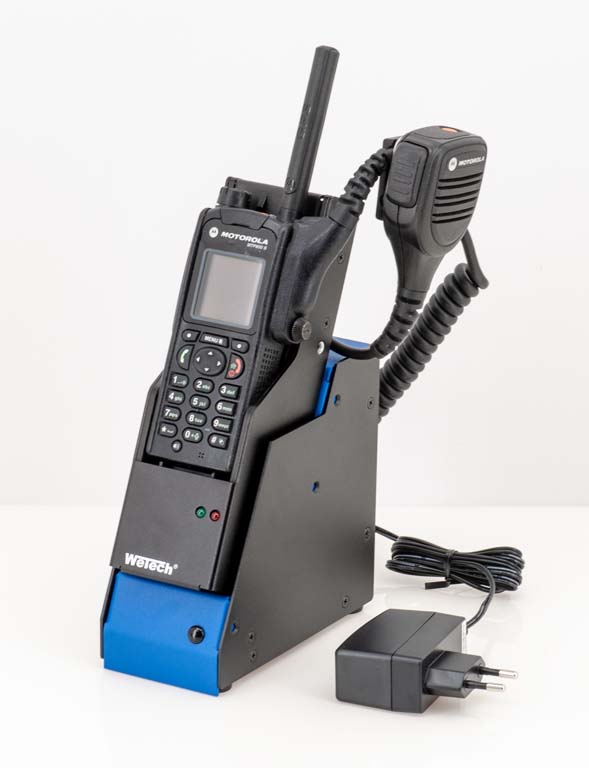 Funkgerät mit Ladestation und Mikrofon, schwarzes Gehäuse, blaues Detail, Netzteil daneben.