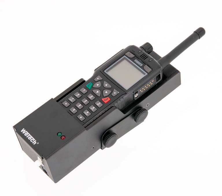 Handfunkgerät mit Tasten auf Ladestation, Antenne nach rechts.